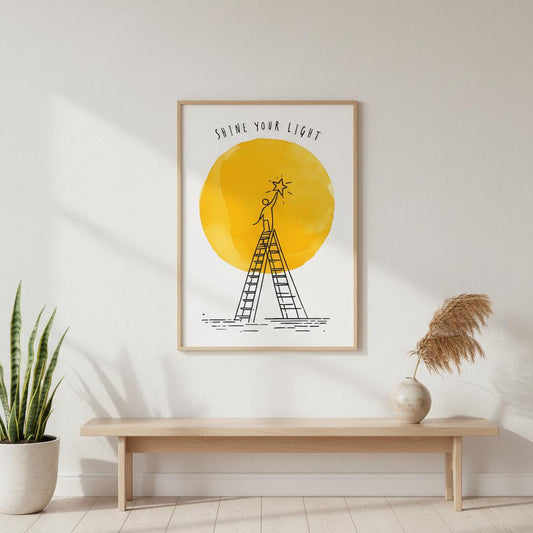 Framed artwork with a yellow circle and ladder illustration on a wall above a wooden bench.