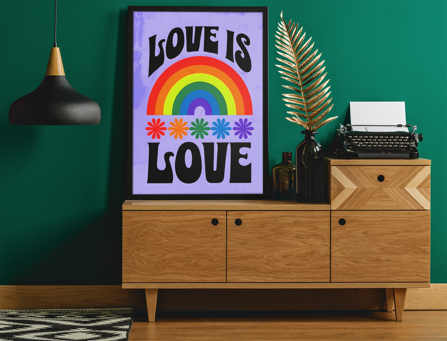 Framed 'Love is Love' poster with rainbow design on a wooden cabinet against a green wall.