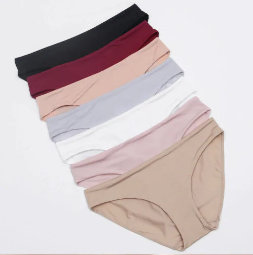 Set of women's underwear in various colors on a light gray background