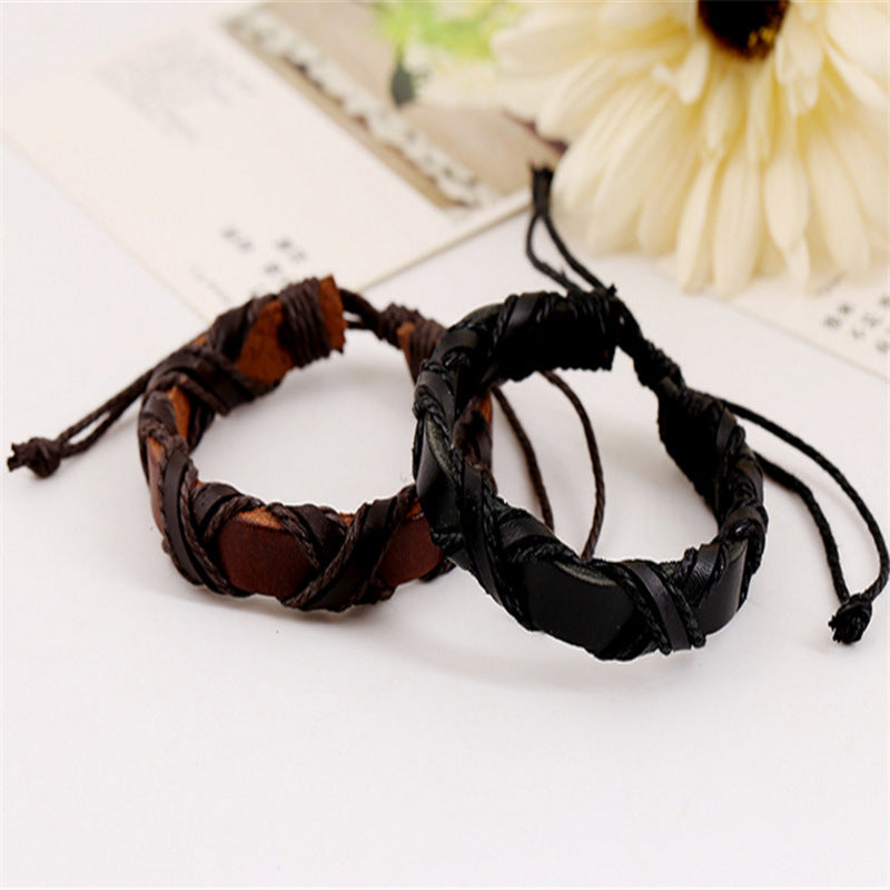 Two braided leather bracelets on a white surface with a blurred background