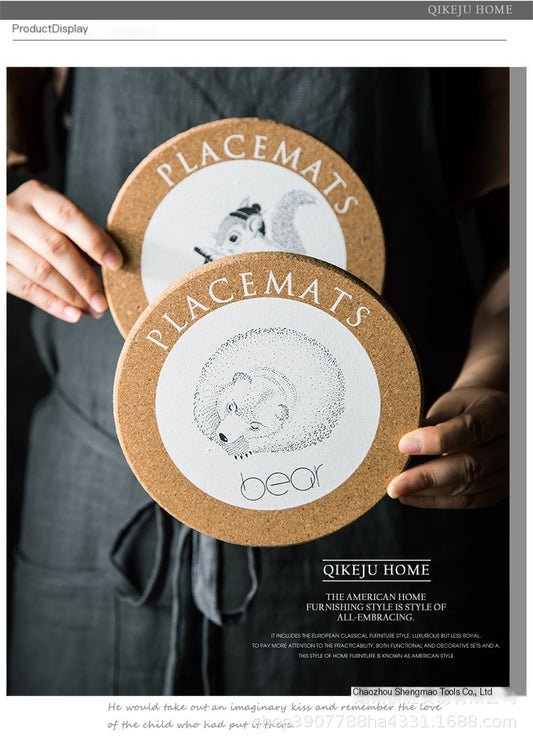 Person holding two placemats with animal illustrations and 'Qikeju Home' branding.