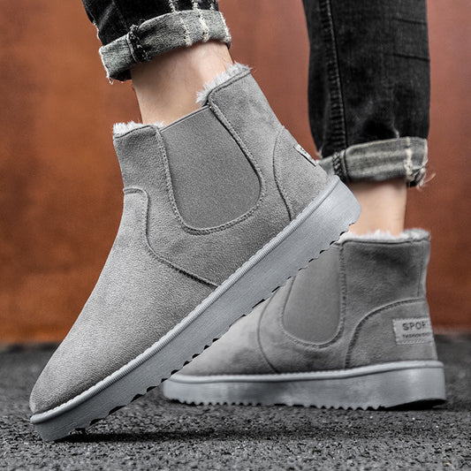 Gray suede ankle boots with fur lining worn by a person on a blurred background