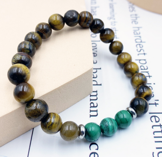 Beaded bracelet with green and brown stones on a newspaper background