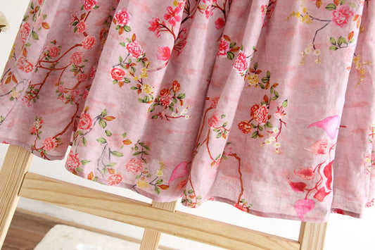 Floral-patterned pink fabric on a wooden stand