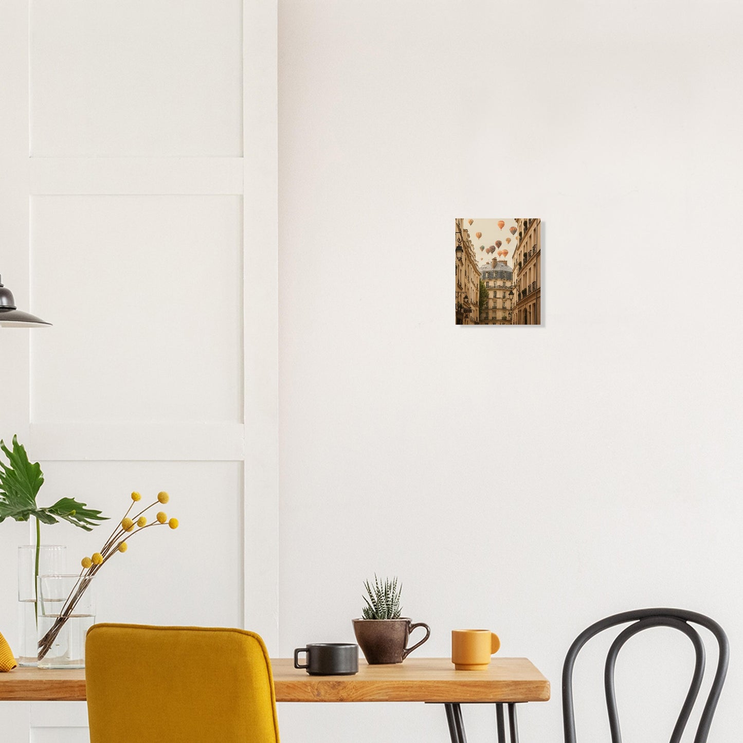 Modern interior with a wooden table, yellow chair, black chair, and wall art.