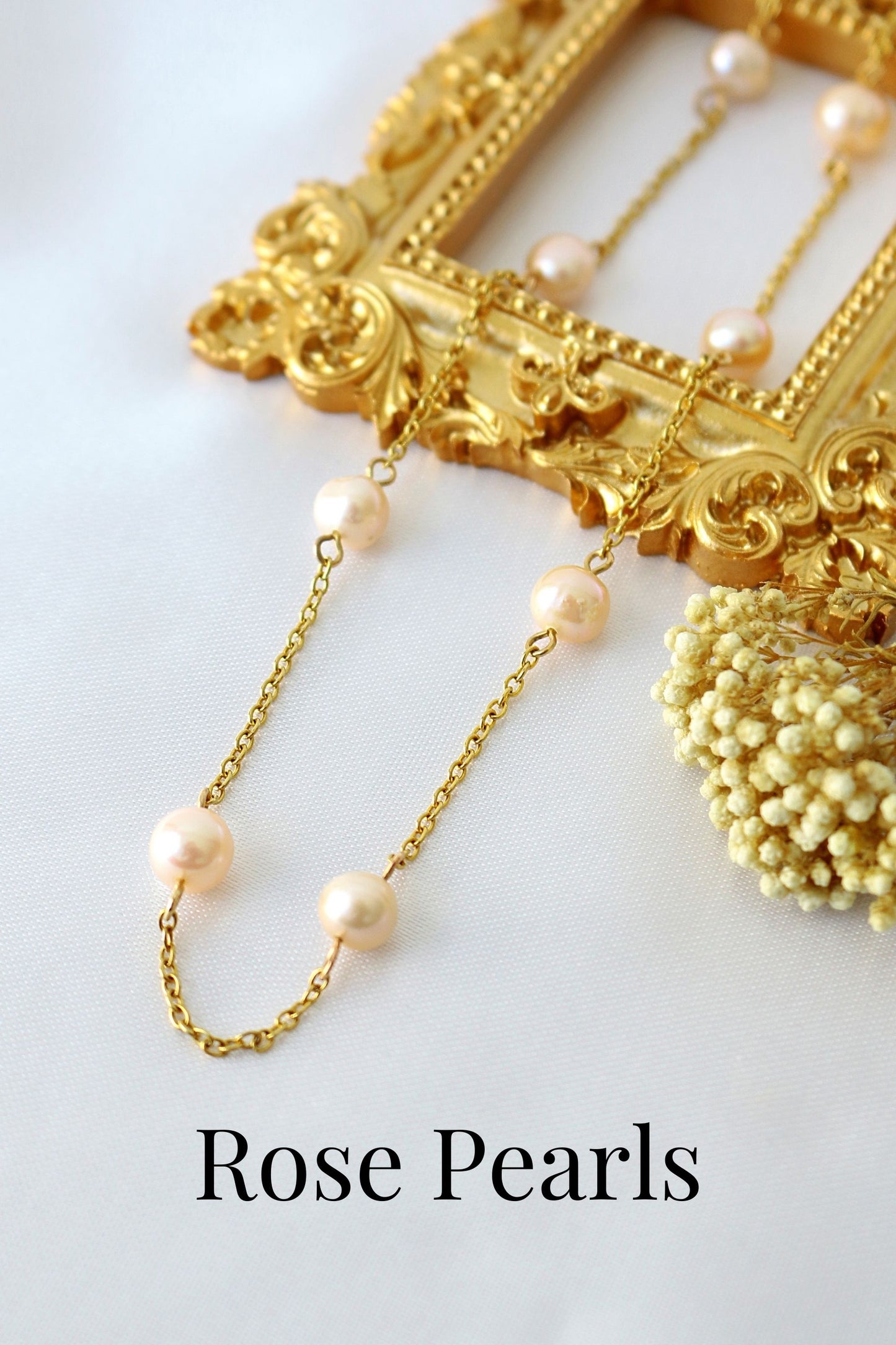 Gold necklace with rose pearls on a white background