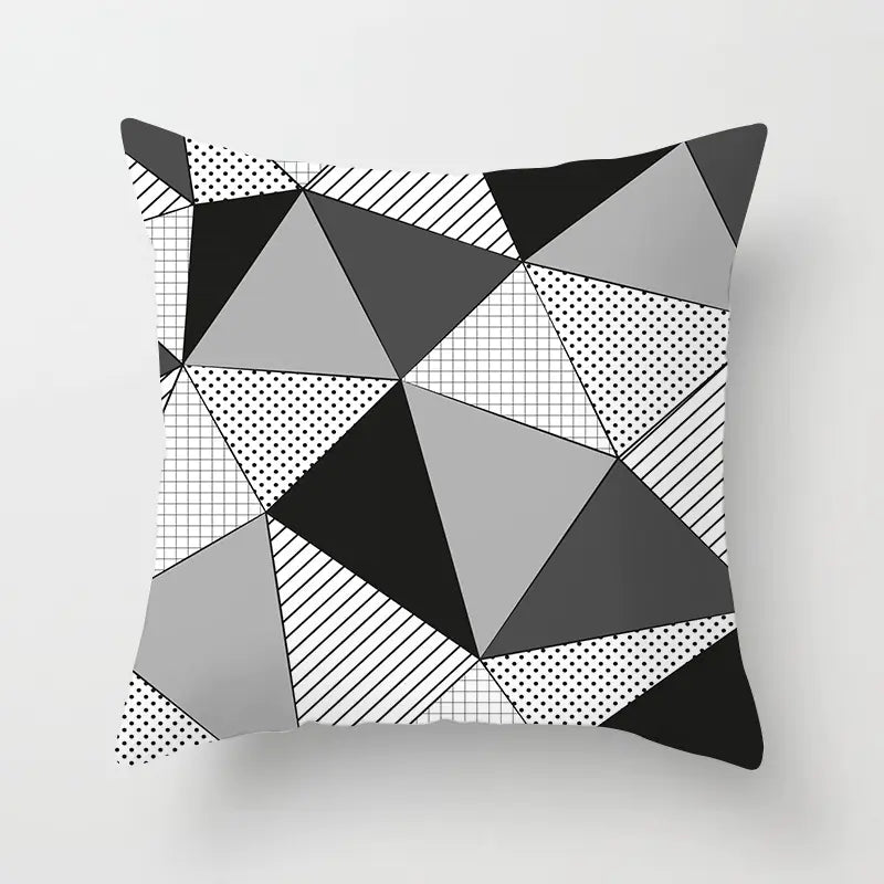 Geometric patterned pillow with triangles on a light gray background