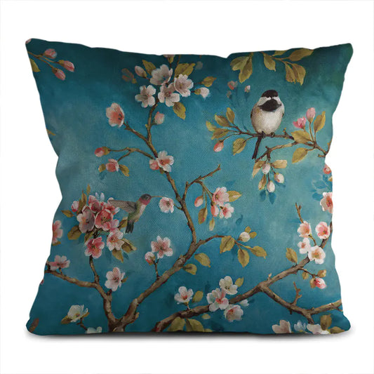 Decorative pillow with floral and bird design on a blue background