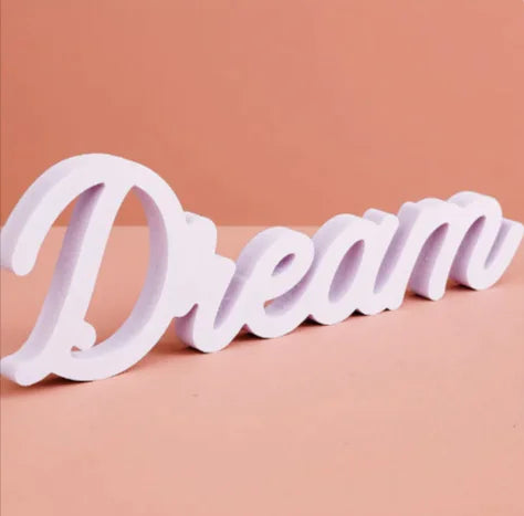 White decorative word 'Dream' on a pink background