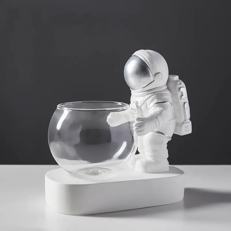 Astronaut figurine with a glass bowl on a dark background