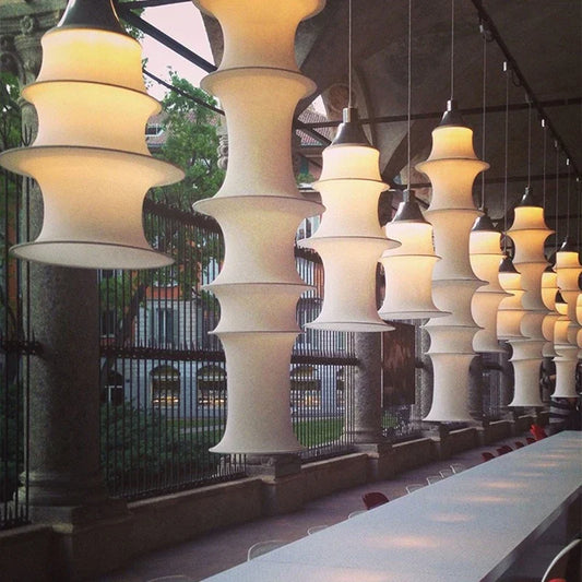 Modern pendant lights hanging above a dining area with outdoor view