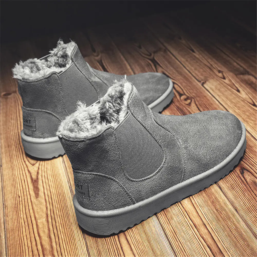 Gray suede ankle boots with fur lining on a wooden floor