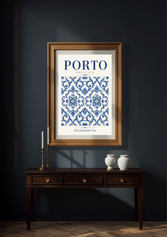 A framed art print featuring a blue and white damask pattern with the text 'PORTO,Portugal' and 'The Invincible City' at the bottom, displayed on a dark navy wall above a wooden console table with candles and vases.
