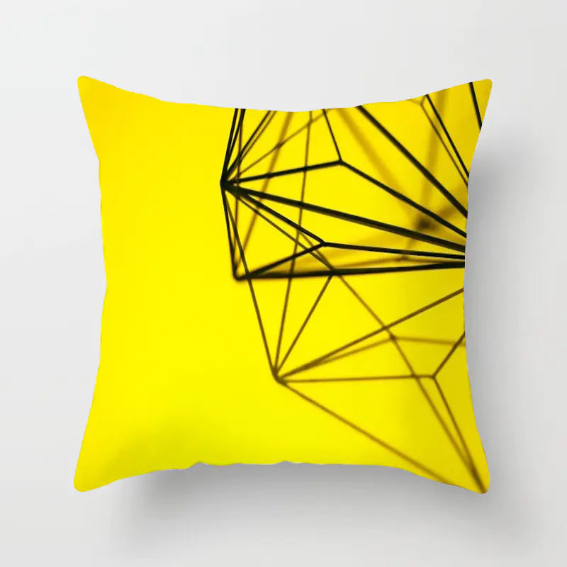 Yellow pillow with black geometric design on a white background