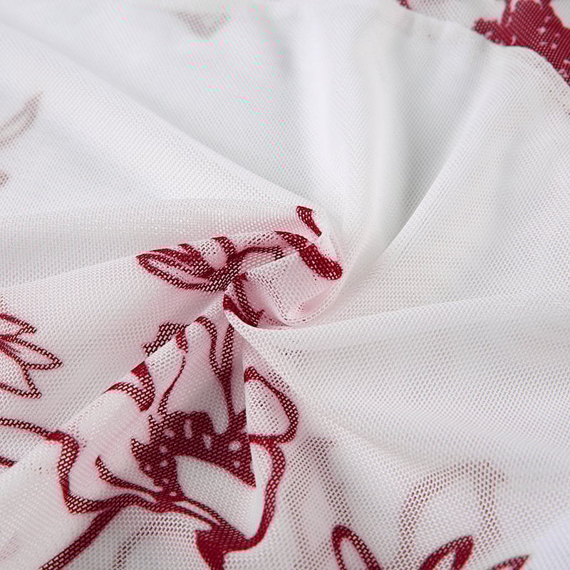 Close-up of white fabric with red floral embroidery
