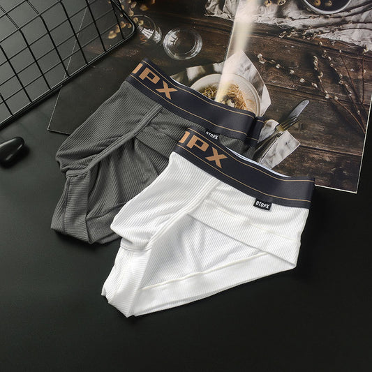 Two pairs of boxer briefs with IPX branding on a dark surface.
