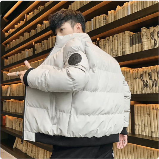 Person wearing a white puffer jacket in front of a bookshelf
