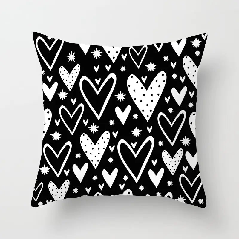 Black pillow with white heart pattern on a light gray background