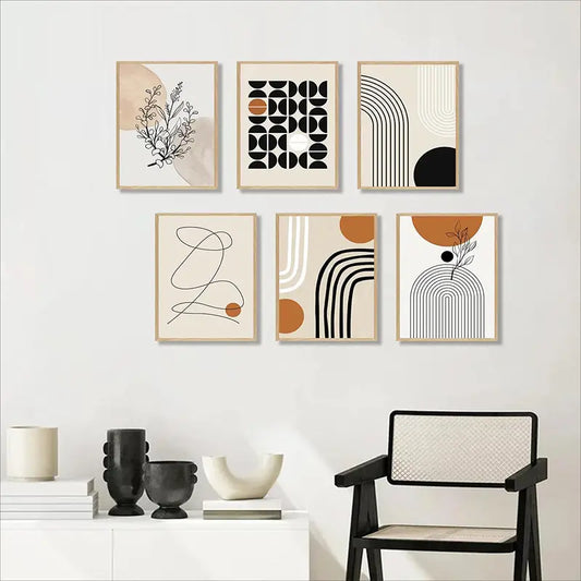 Set of abstract art prints on a wall with a chair and decorative items below.