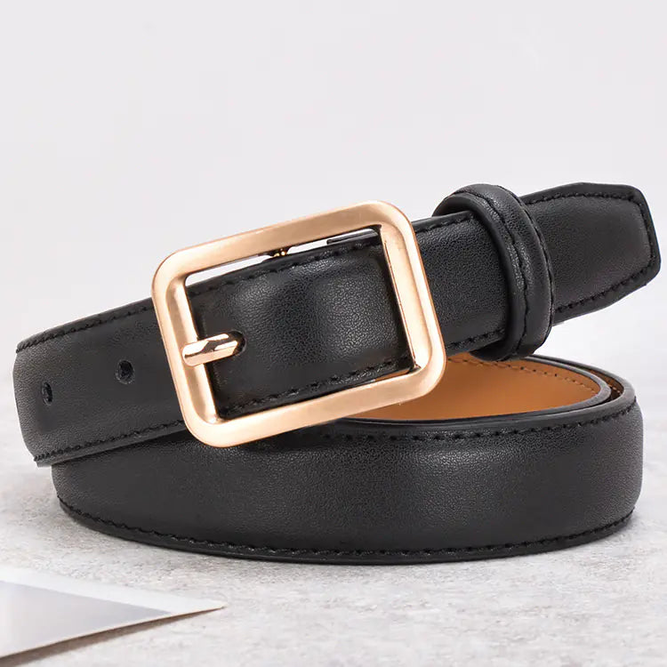 Black leather belt with a rose gold buckle on a light gray background