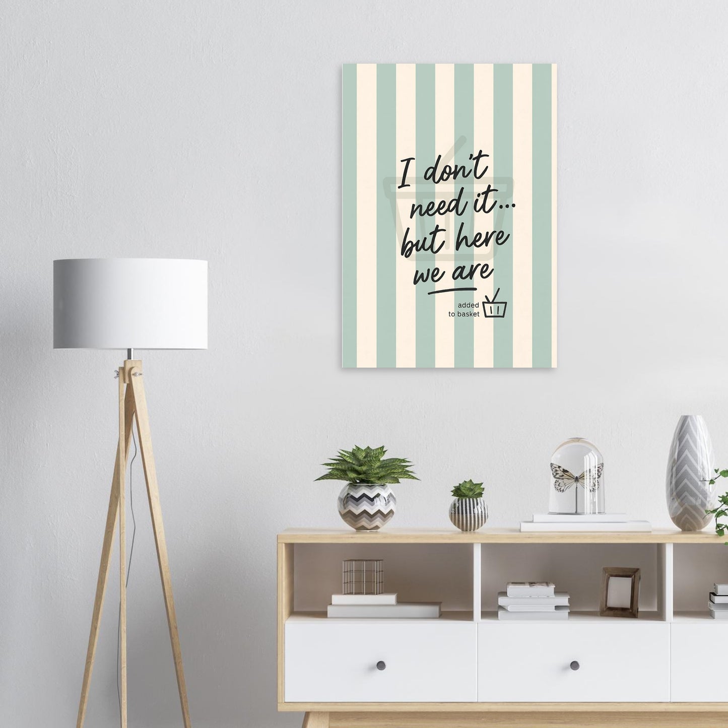 Decorative wall art with striped pattern and text in a room with a lamp and shelves.
