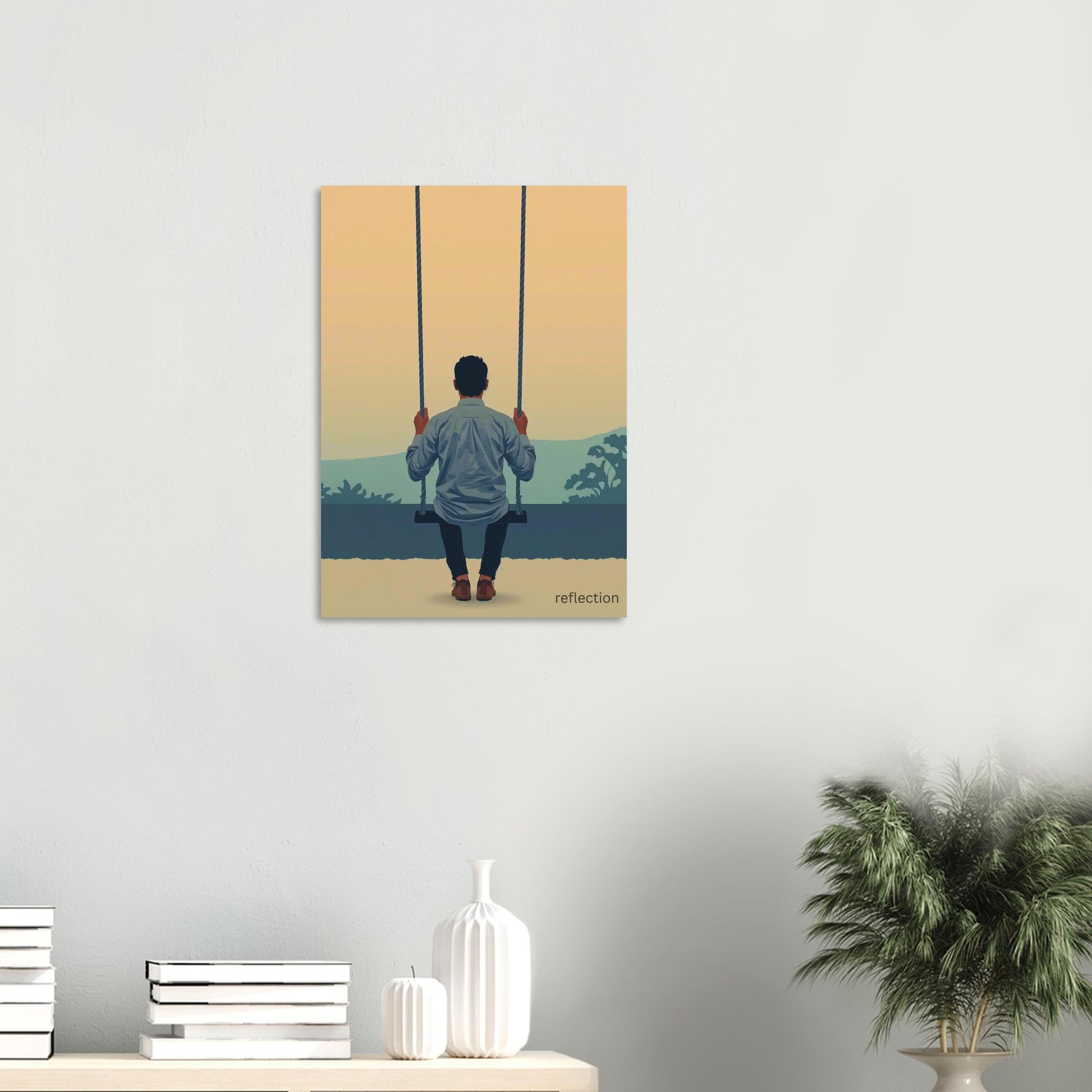 Canvas print of a man on a swing against a sunset sky, displayed on a wall above a shelf.