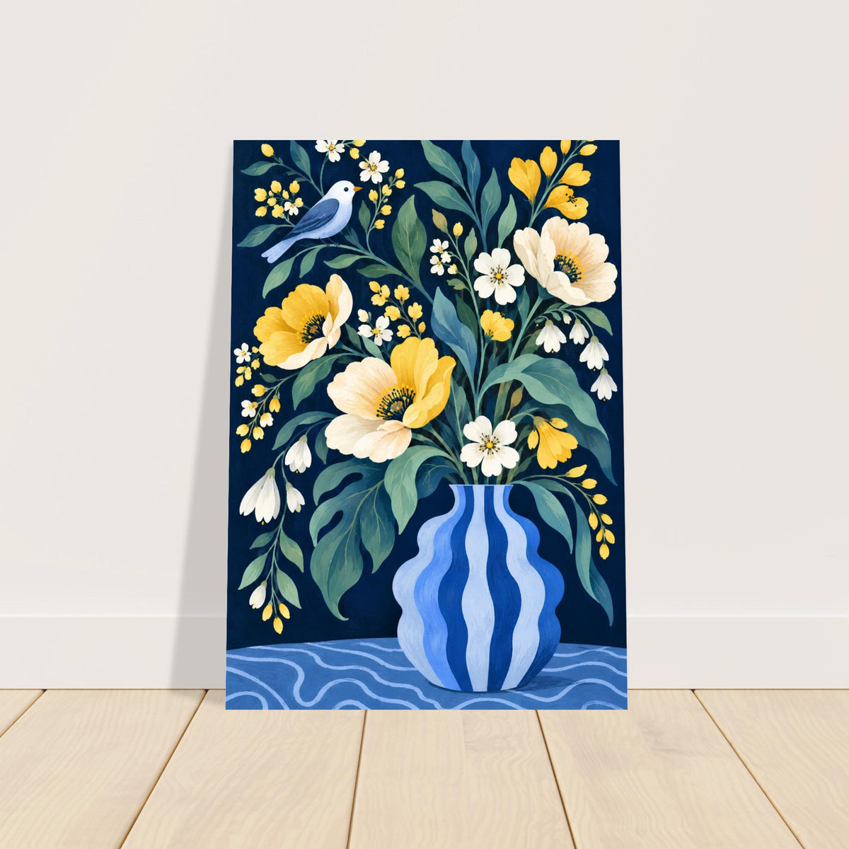 A vertical art print featuring a floral bouquet in a blue patterned vase with yellow and white flowers, green leaves, and a small blue bird, shown leaning against a white wall on a light wood floor.