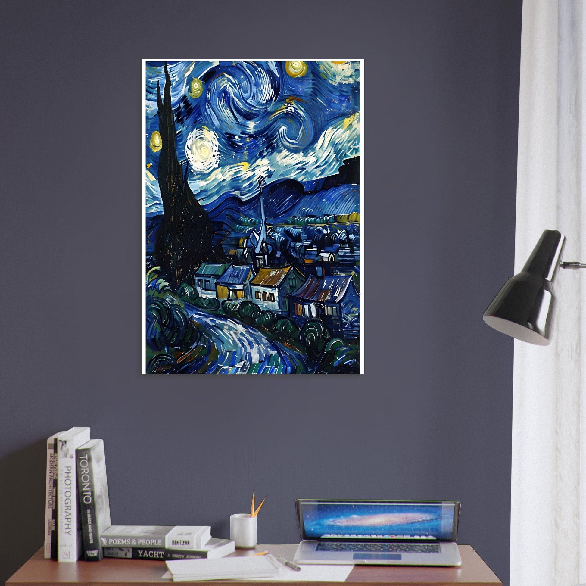 Framed artwork of 'Starry Night' by Van Gogh on a wall above a desk with books and a laptop.