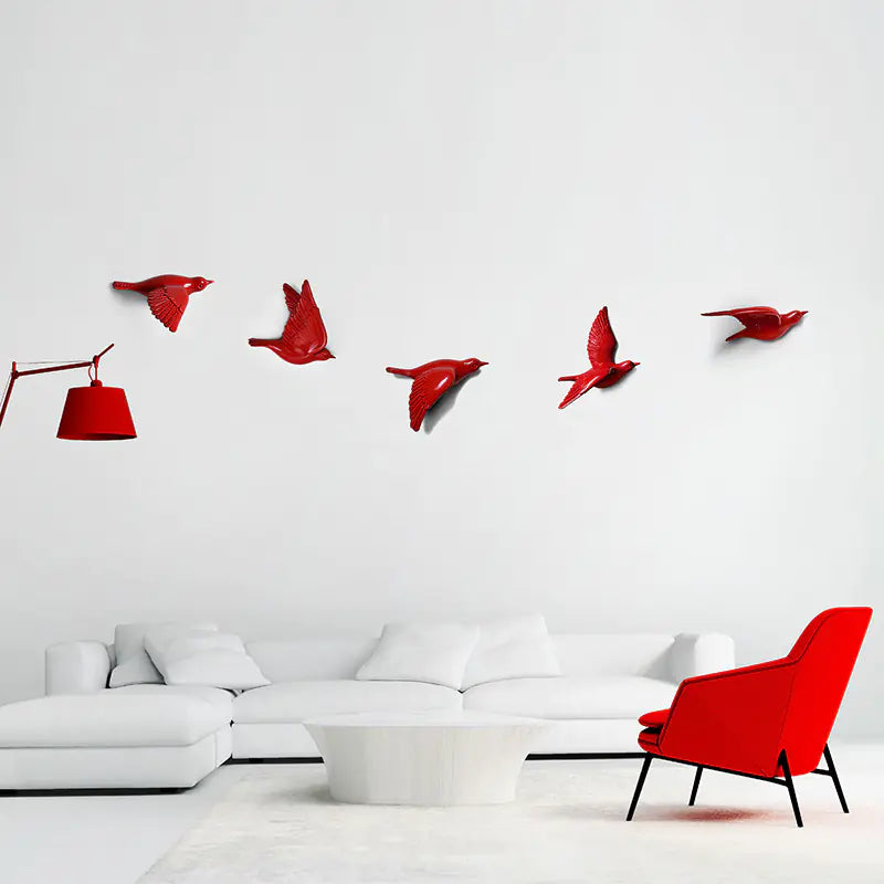 Modern living room with a red chair and decorative red birds on the wall.