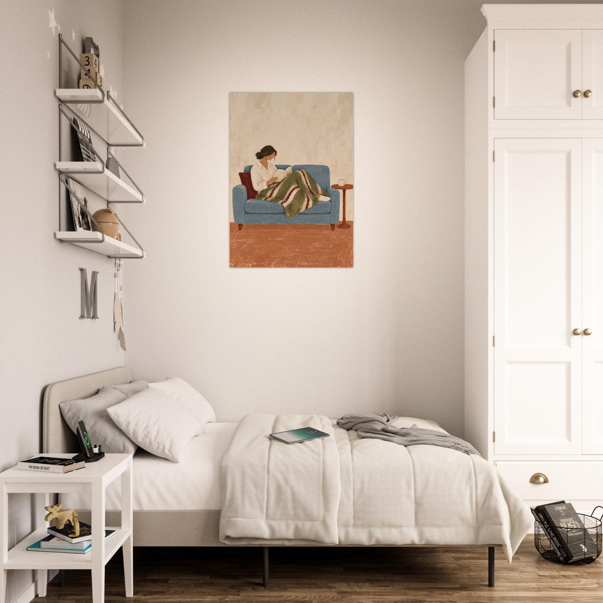 Woman reading print on a pale bedroom wall beside white shelving, a desk and neutral bedding.