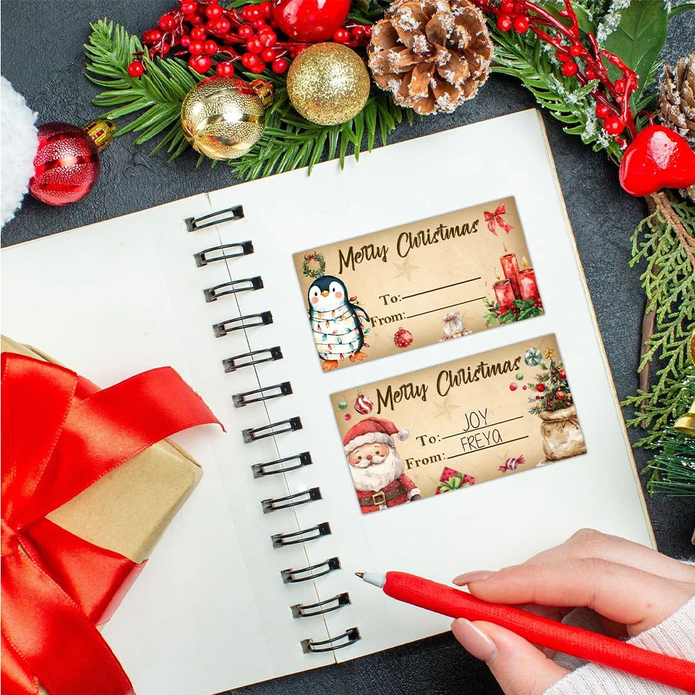 Notebook with Christmas-themed gift tags and decorative items on a dark surface