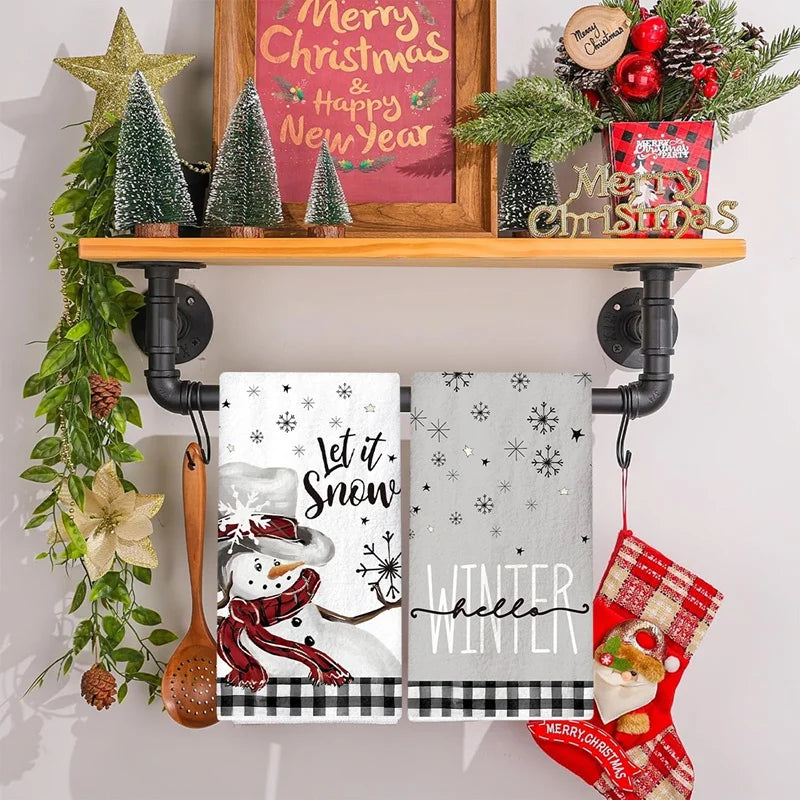 Decorative shelf with Christmas-themed items including a framed sign, small trees, and towels.