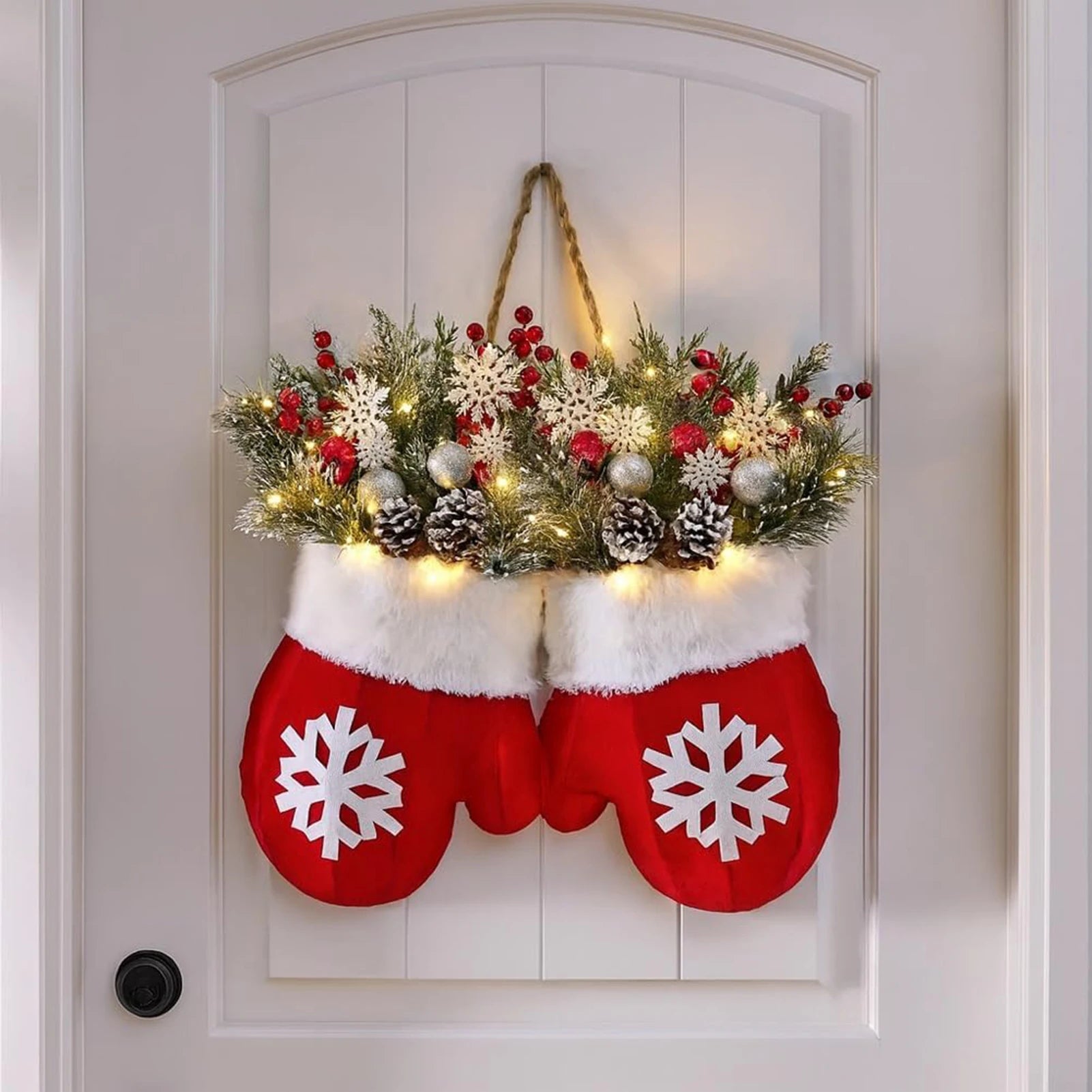 Decorative Christmas mittens with a floral arrangement on a white door.