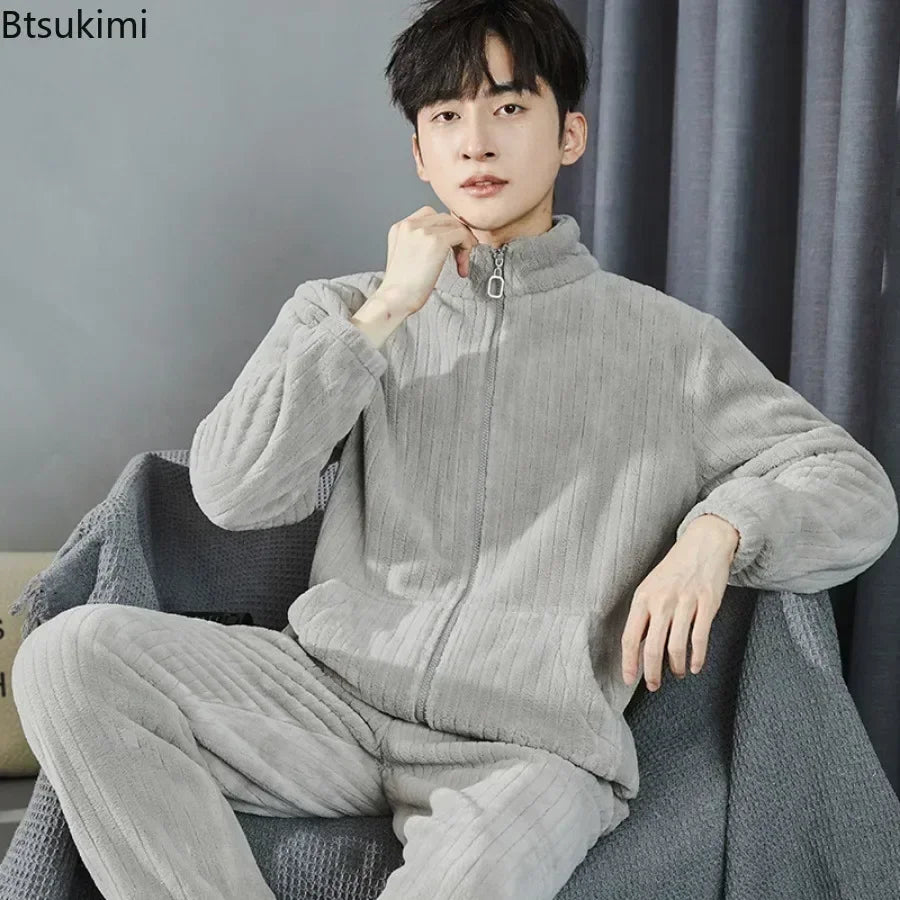 Person wearing a gray fleece tracksuit sitting on a couch with a plain background