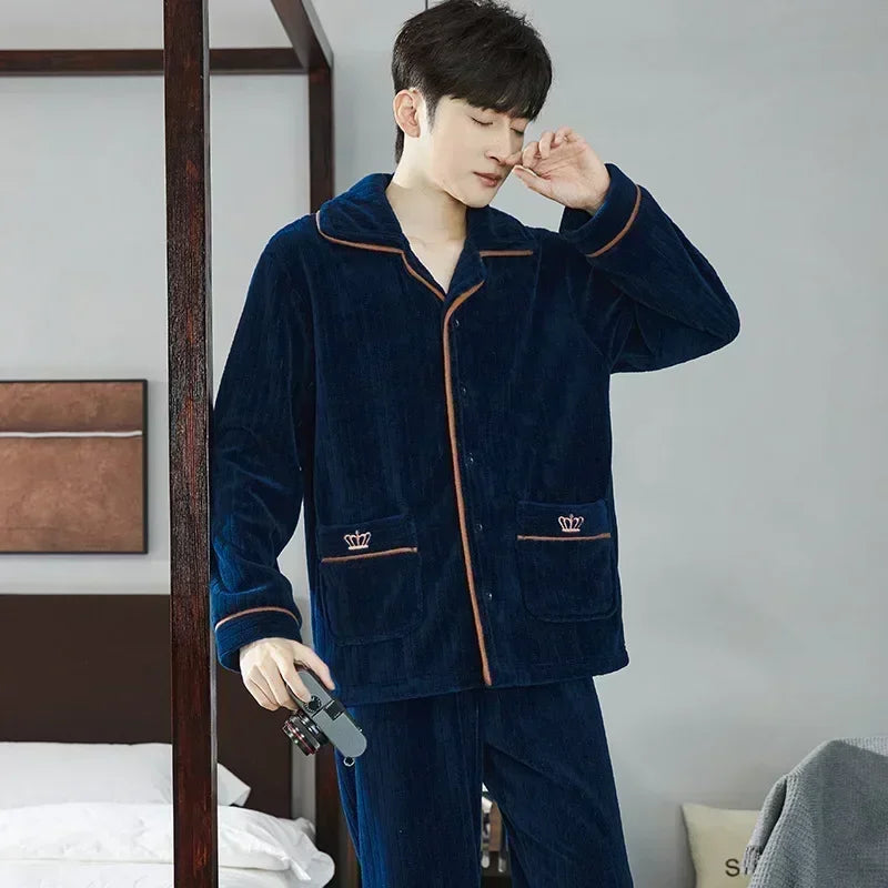 Person wearing a navy blue pajama set with brown accents in a bedroom setting.