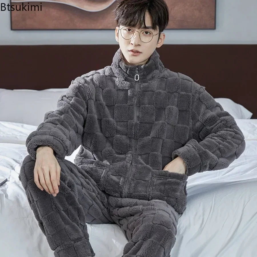 Person wearing a gray checkered onesie sitting on a bed.