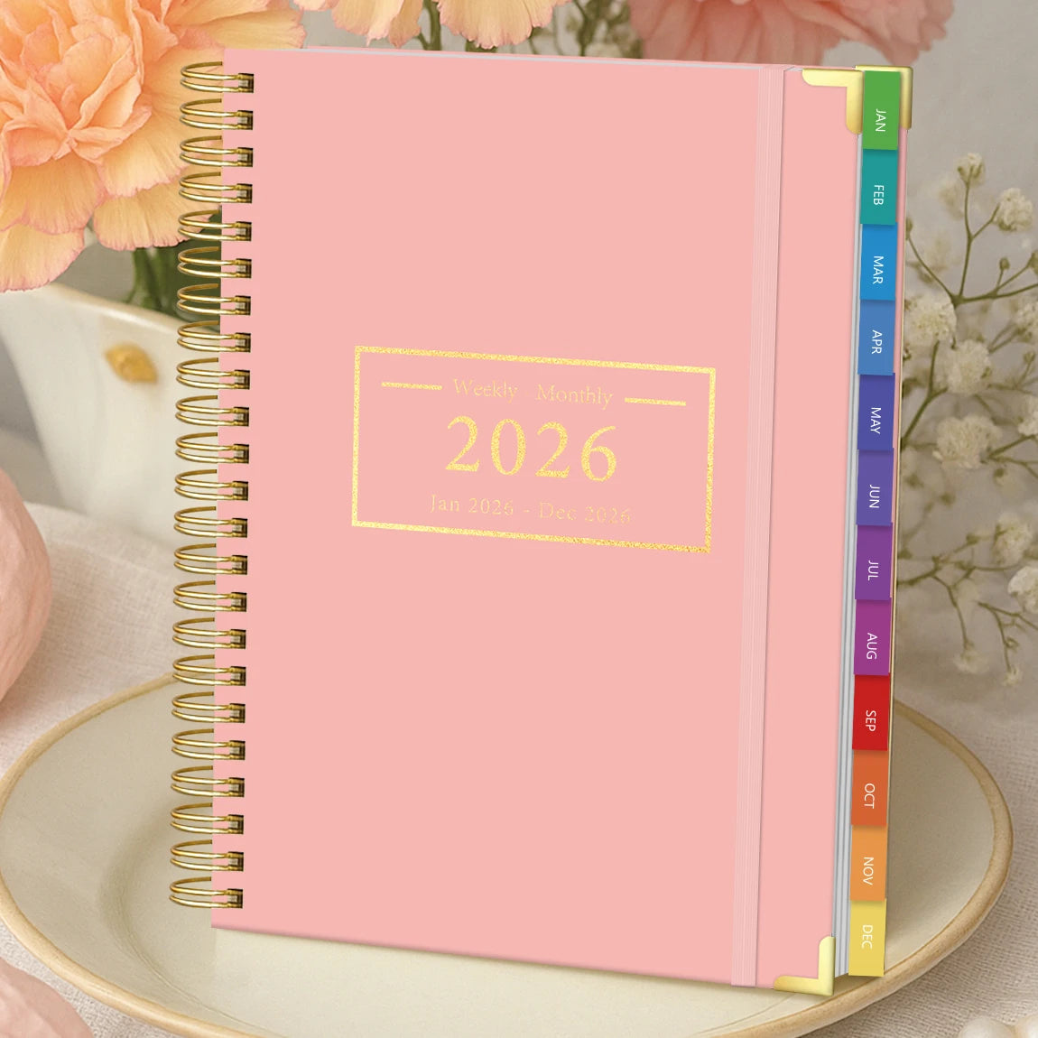 Pink 2026 A5 diary style planner with divider tabs and spiral binding, desktop flatlay with flowers