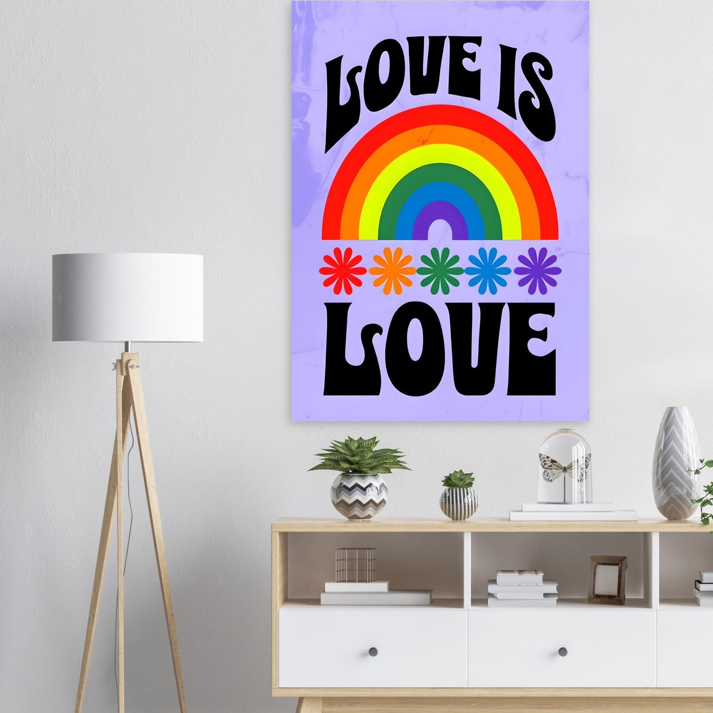 Decorative wall art with rainbow and 'Love is Love' text in a room with a lamp and shelf.