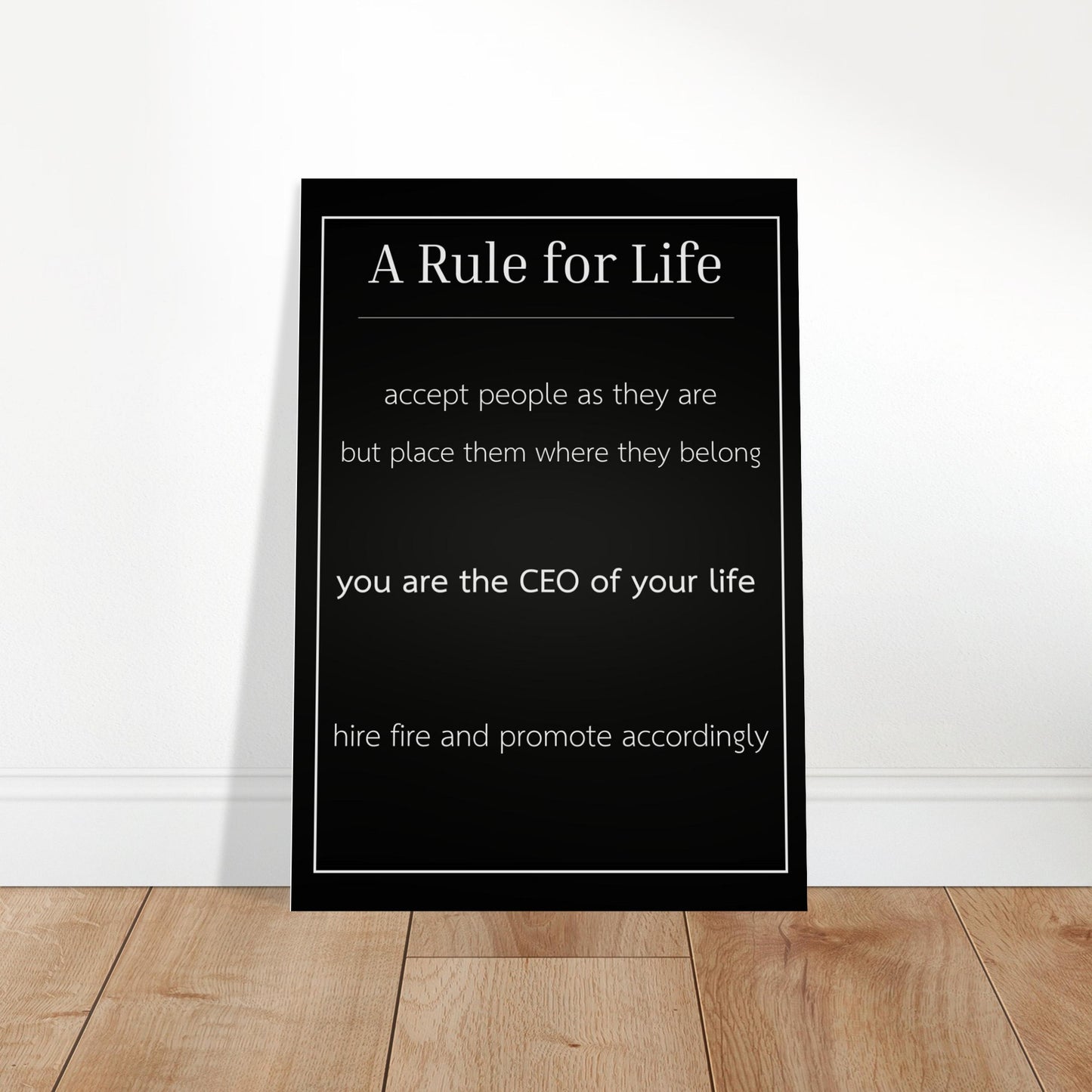 Black framed poster with motivational quote on a white wall.