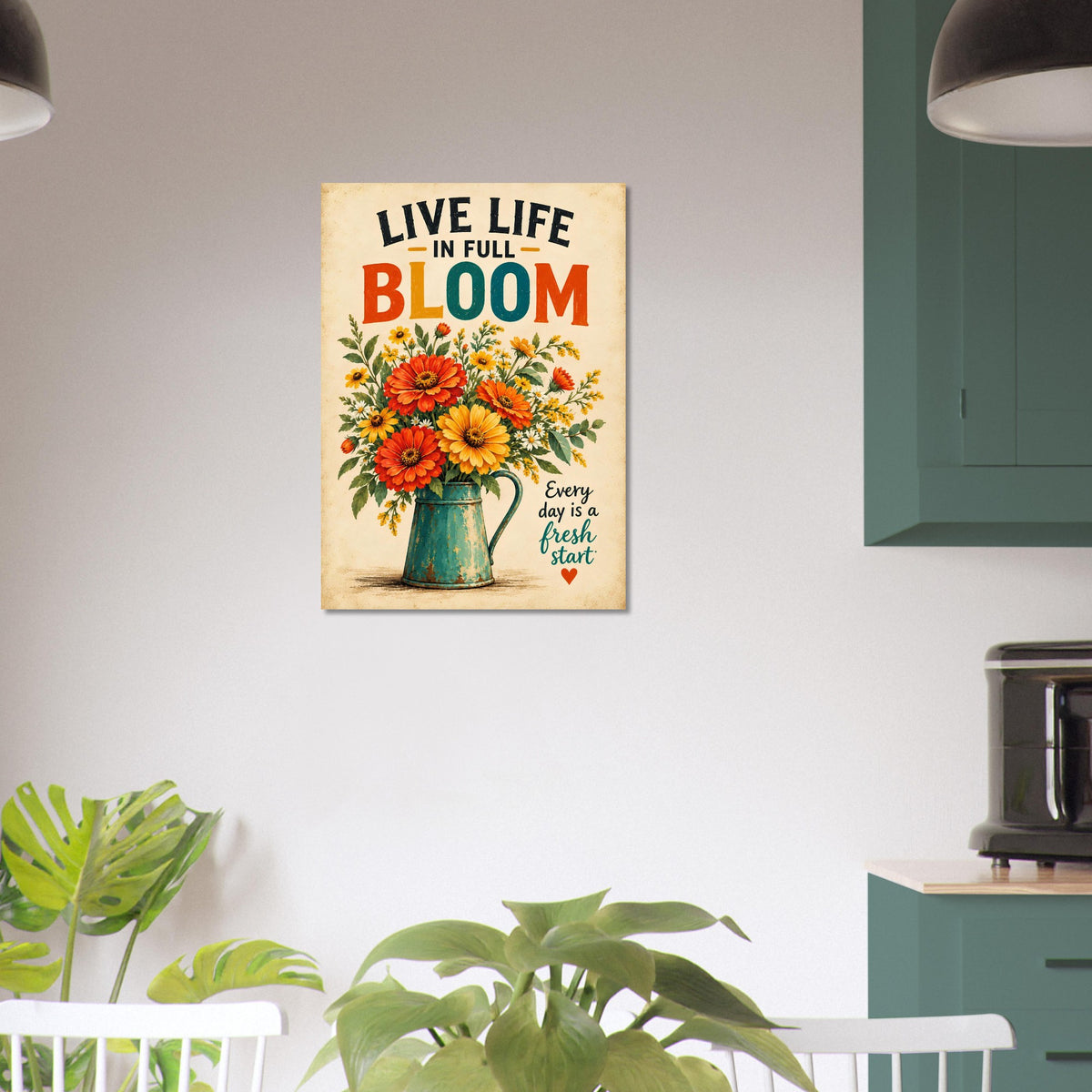 A vertical metal wall art print featuring a colorful floral bouquet in a teal pitcher with the text 'LIVE LIFE IN FULL BLOOM' and 'Every day is a fresh start', displayed on a light gray wall in a modern kitchen setting.