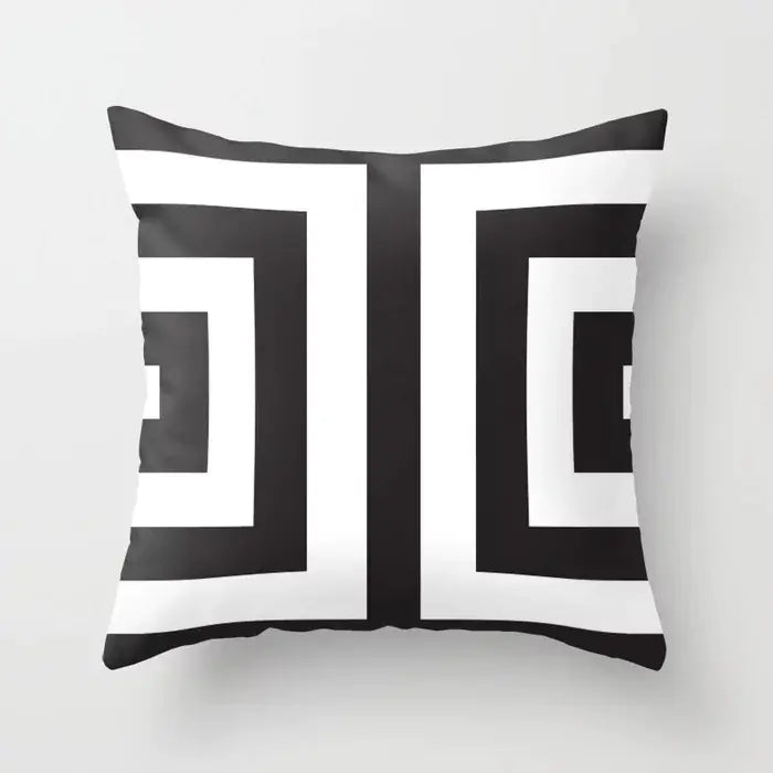 Black and white geometric patterned pillow on a light gray background