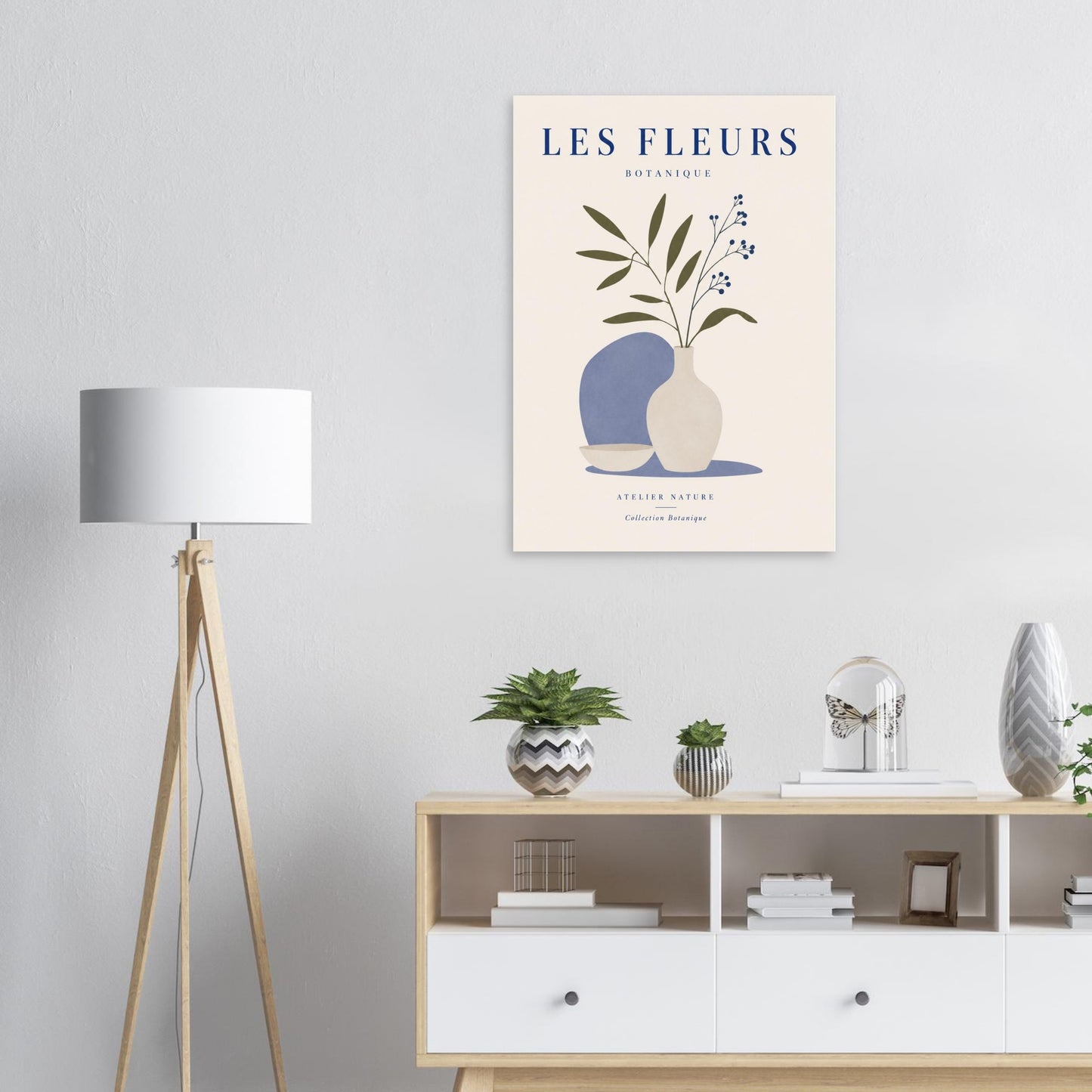 Scandinavian botanical wall art with blue vase displayed above modern sideboard and lamp
