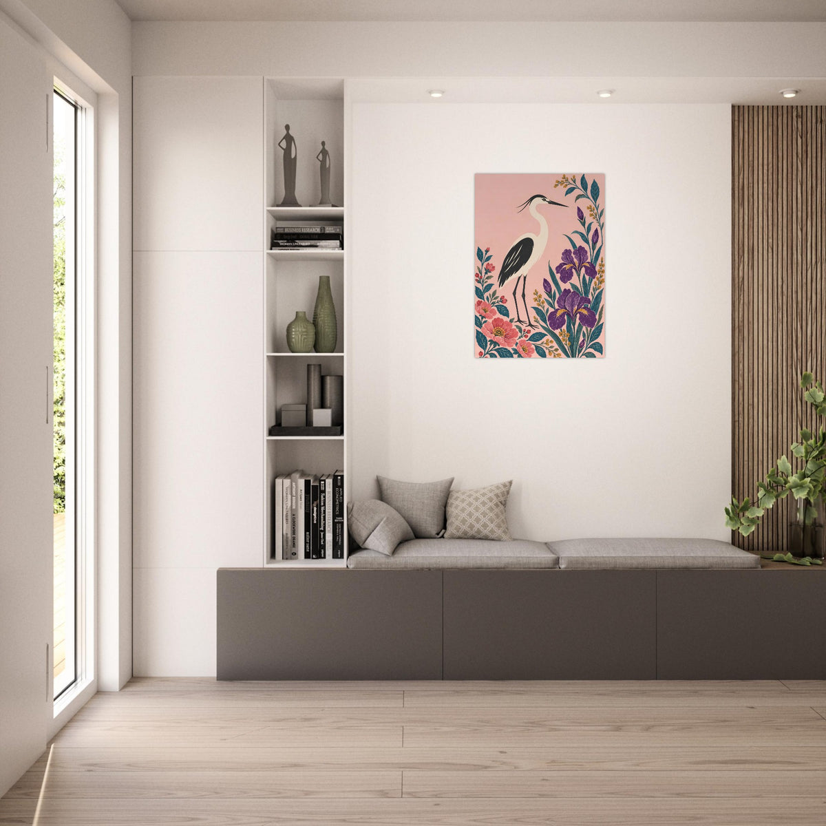 A vertical wall art print featuring a pink background with a heron and colorful floral elements, displayed in a modern, minimalist living room setting above a gray bench.