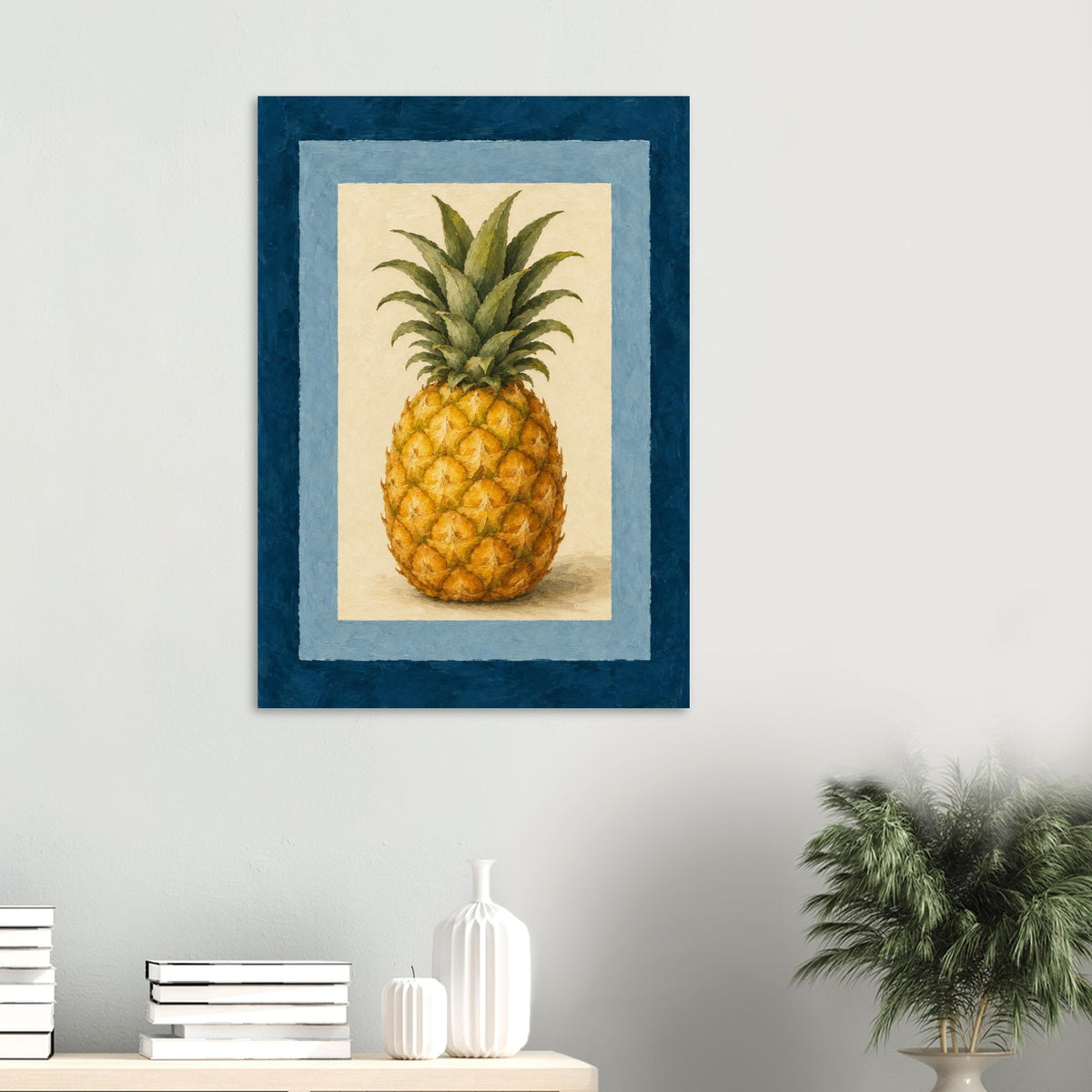 A framed wall art print featuring a detailed pineapple illustration, displayed on a light gray wall above a console table with books and a plant.