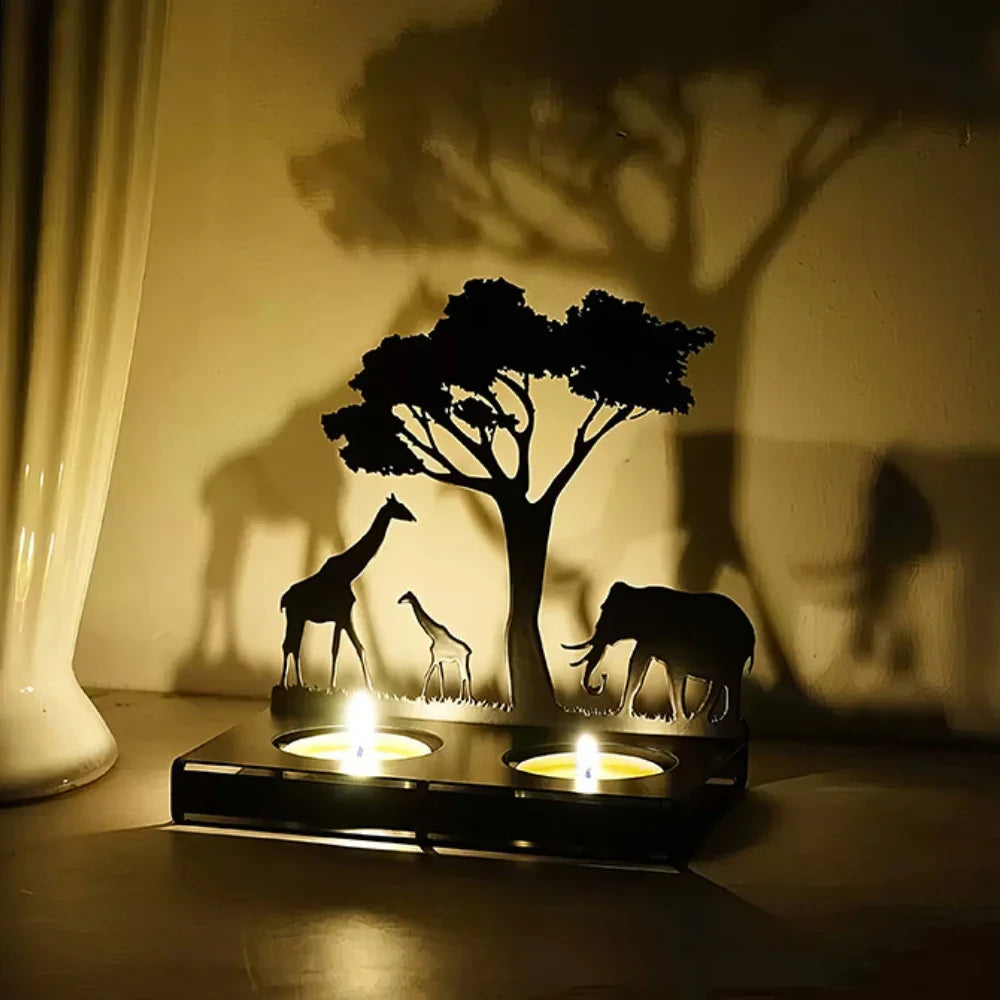 Shadow play with giraffe, elephant, and tree on a wall with candlelight.