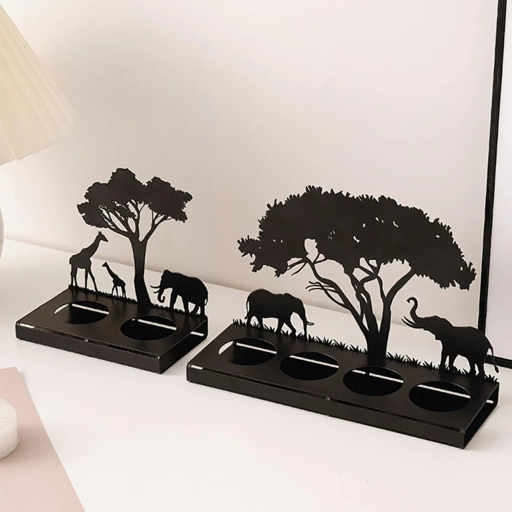 Decorative candle holders with African animal and tree design on a white surface.