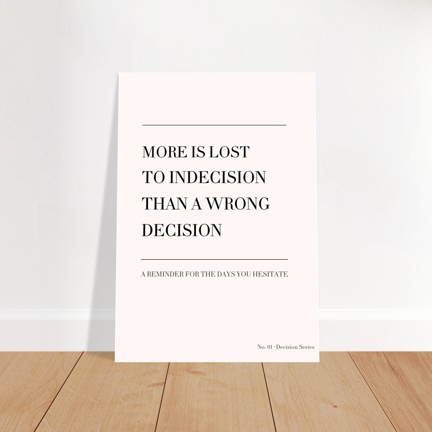 Beige typography poster “More is lost to indecision than a wrong decision” standing on wooden floor