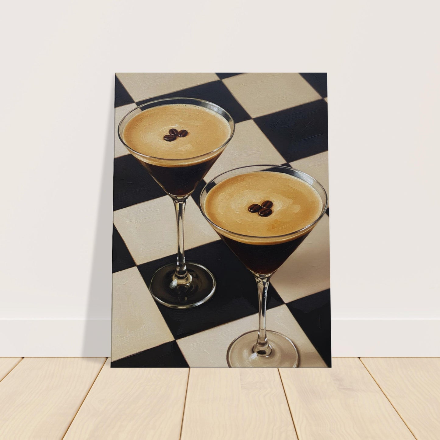A vertical canvas leaning against a white wall on a light wood floor, showing two martini glasses filled with dark cocktails on a black-and-cream checkered surface.