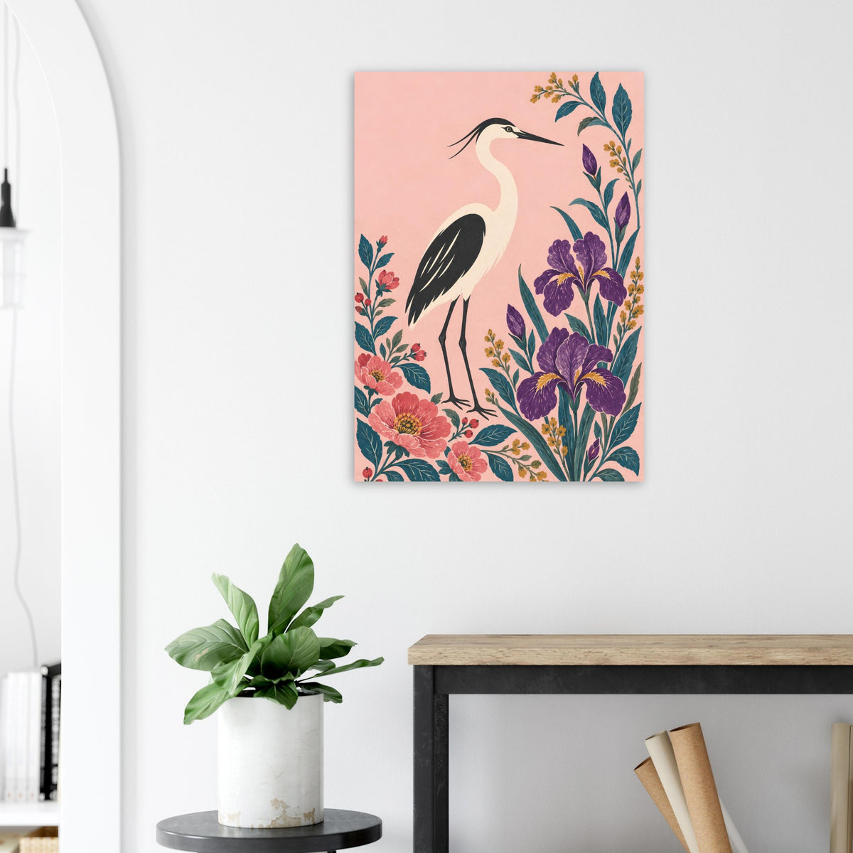 A vertical canvas wall art print featuring a heron bird and colorful flowers, displayed on a white wall in a modern room setting above a console table.