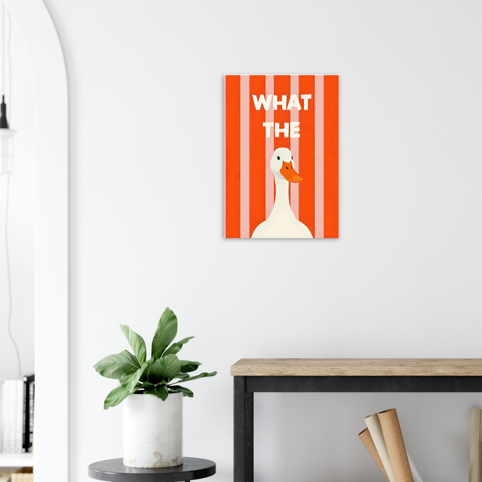 Canvas print with a duck illustration and text on a white wall above a desk.
